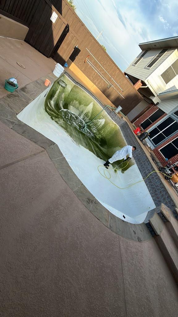 Technician cleaning the drained pool surface