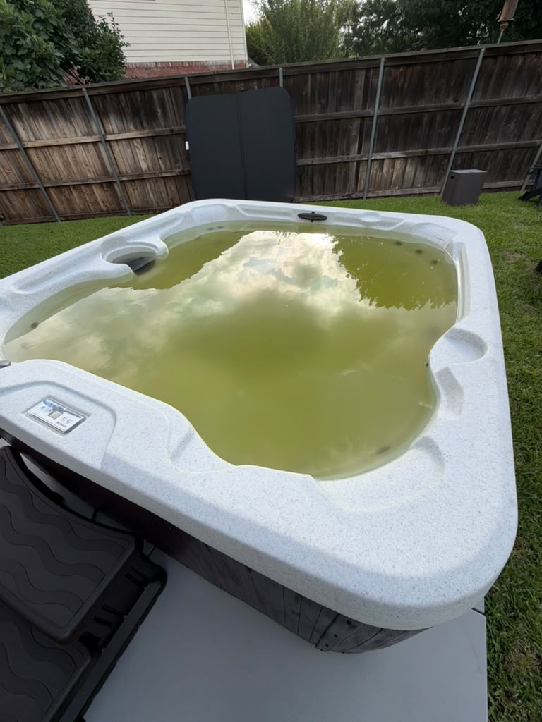 Hot tub with murky green water before recovery